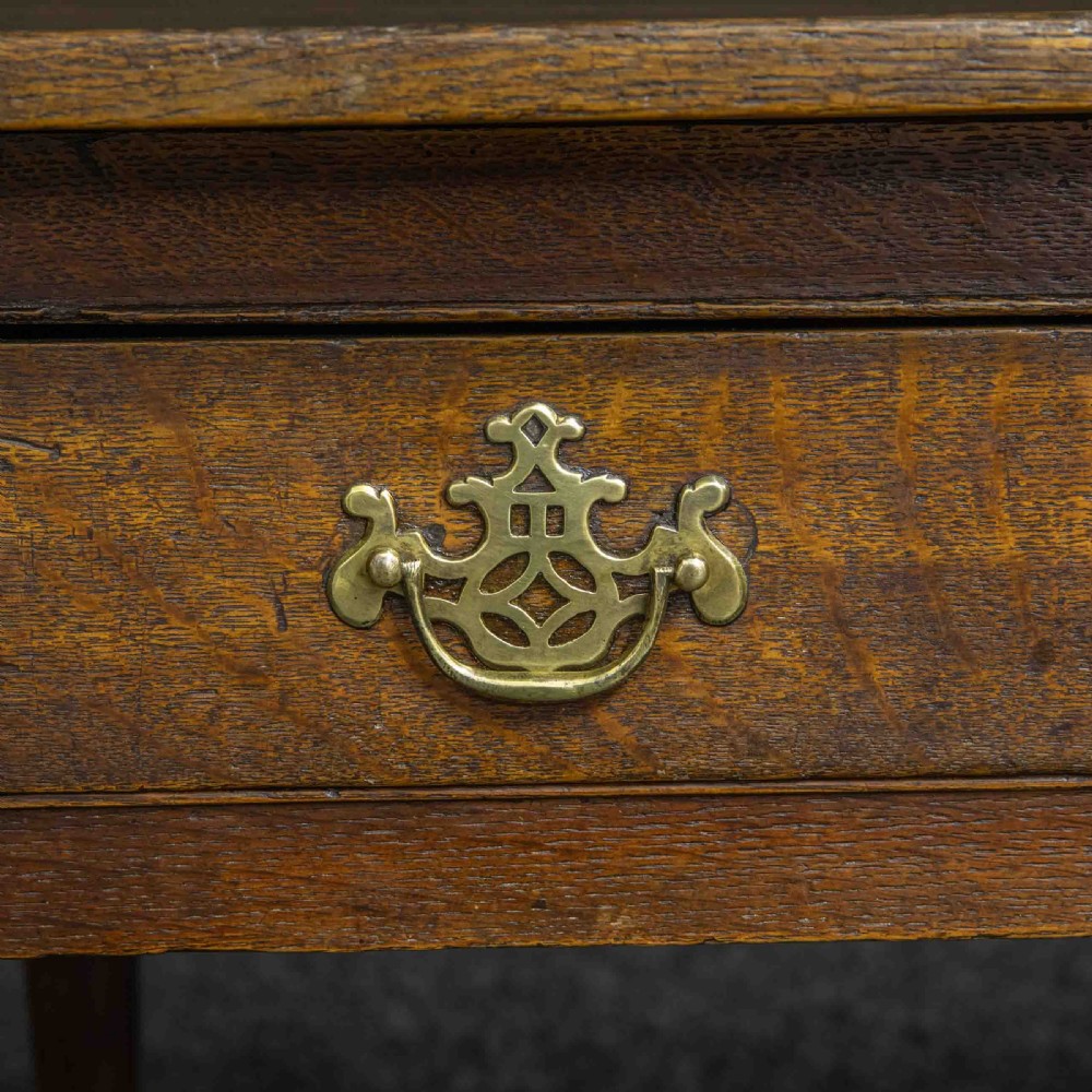 A seventeenth-century warm brown oak sofa table featuring side drop-leaf extensions, a single drawer with brass handles, and tapered legs ending in pad feet. View III