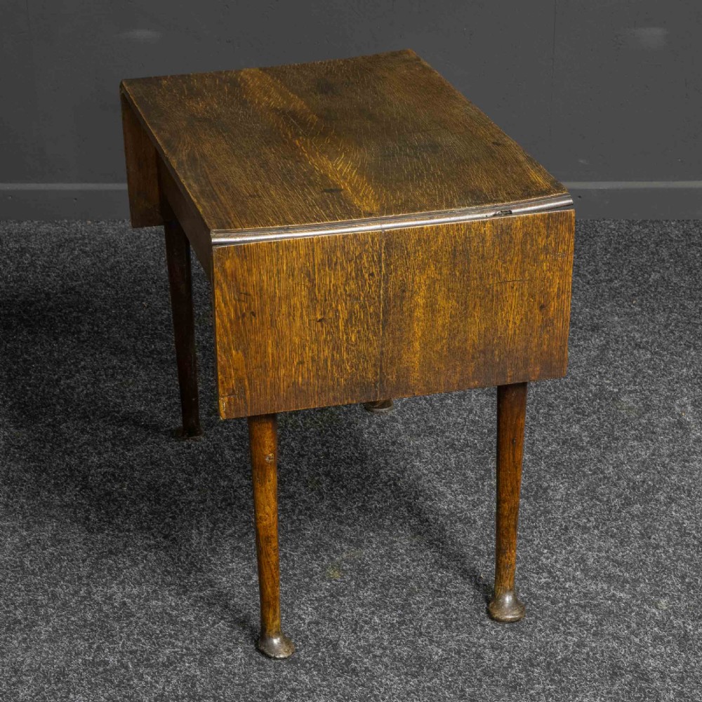 A seventeenth-century warm brown oak sofa table featuring side drop-leaf extensions, a single drawer with brass handles, and tapered legs ending in pad feet. View IX