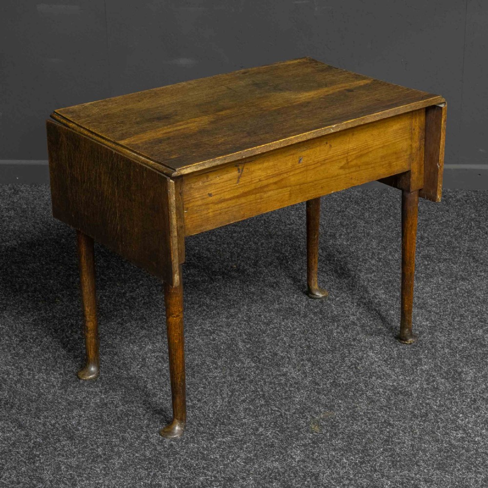 A seventeenth-century warm brown oak sofa table featuring side drop-leaf extensions, a single drawer with brass handles, and tapered legs ending in pad feet. View X