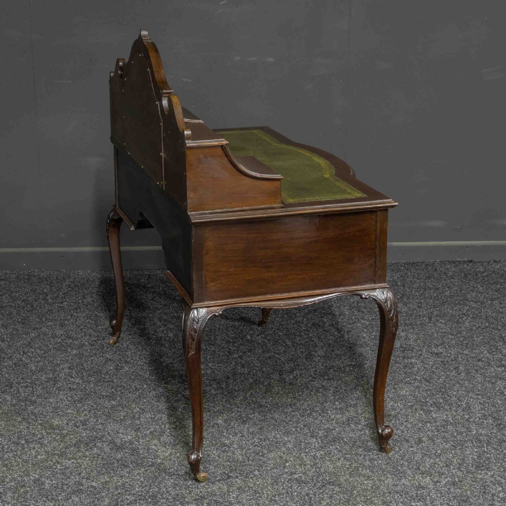 A late Victorian dark mahogany ladies writing desk featuring a green leather inset top, raised mirror superstructure, small side drawers, carved cabriole legs, and brass handles. View VII
