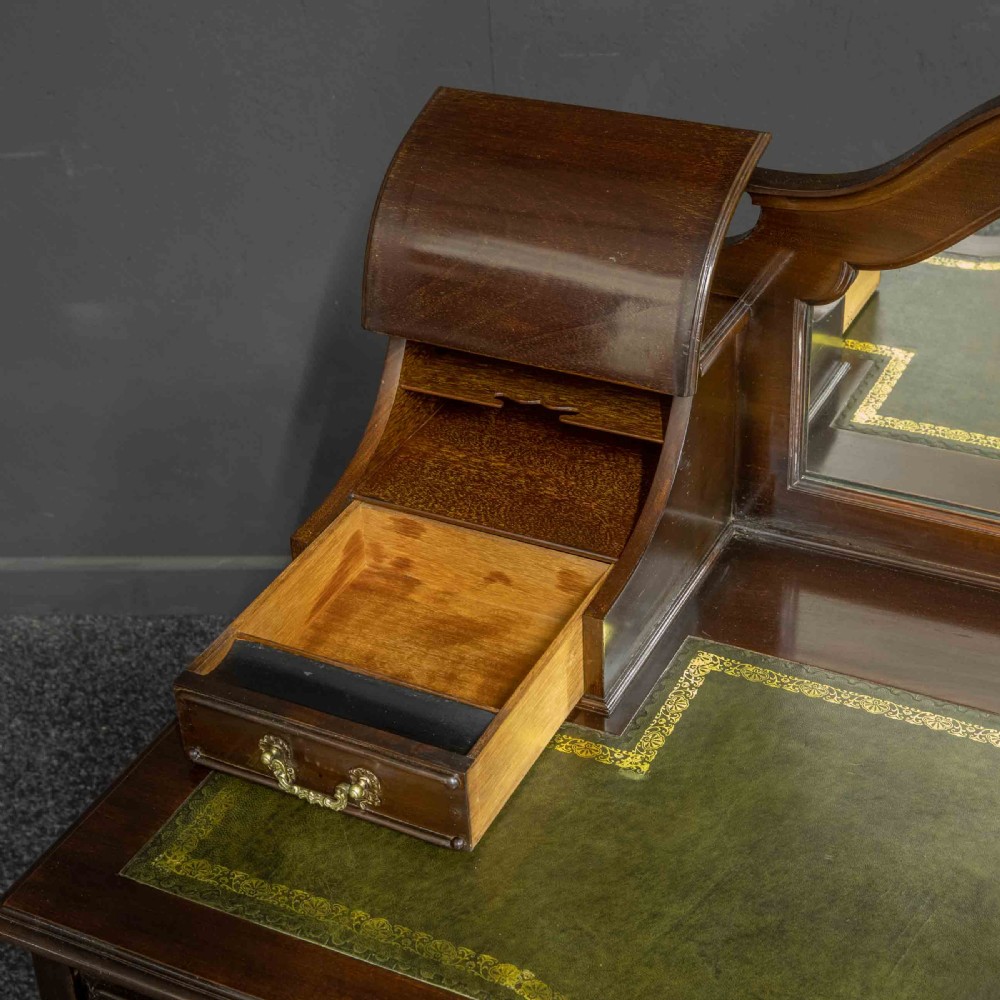 A late Victorian dark mahogany ladies writing desk featuring a green leather inset top, raised mirror superstructure, small side drawers, carved cabriole legs, and brass handles. View VIII