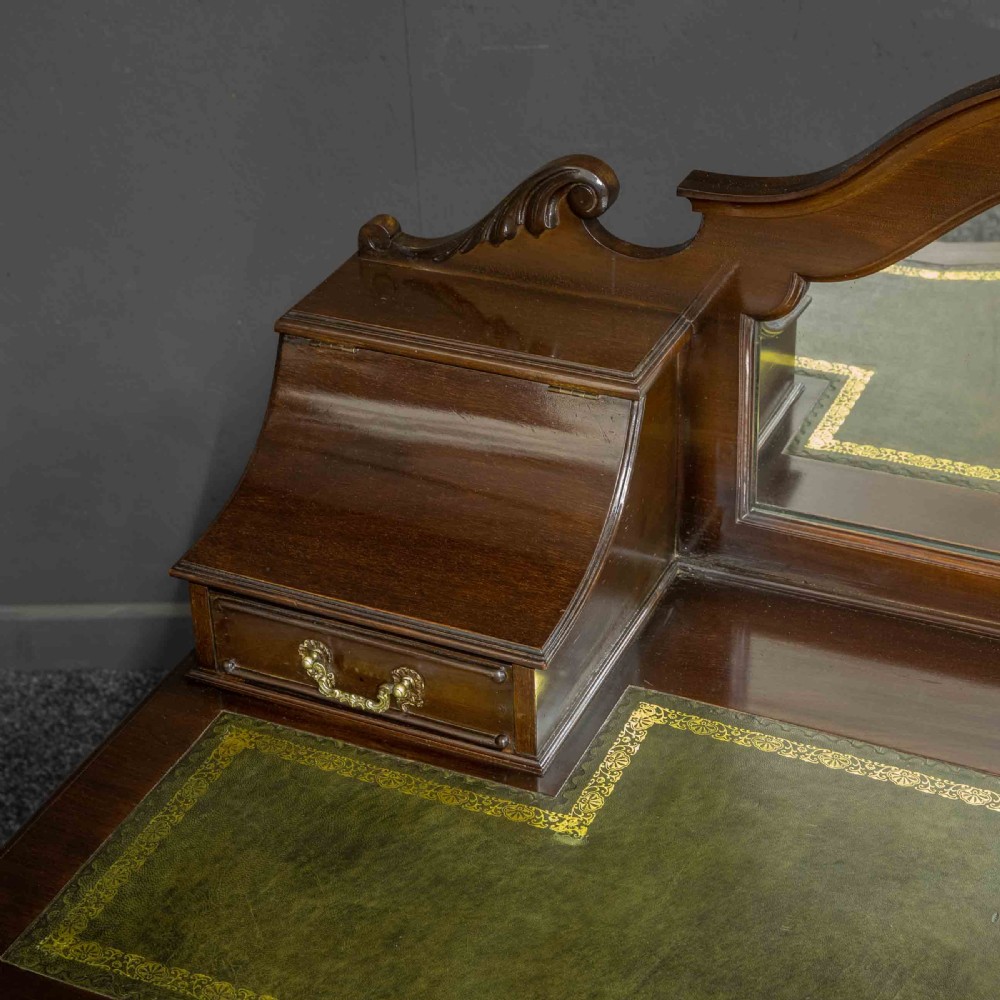 A late Victorian dark mahogany ladies writing desk featuring a green leather inset top, raised mirror superstructure, small side drawers, carved cabriole legs, and brass handles. View IX