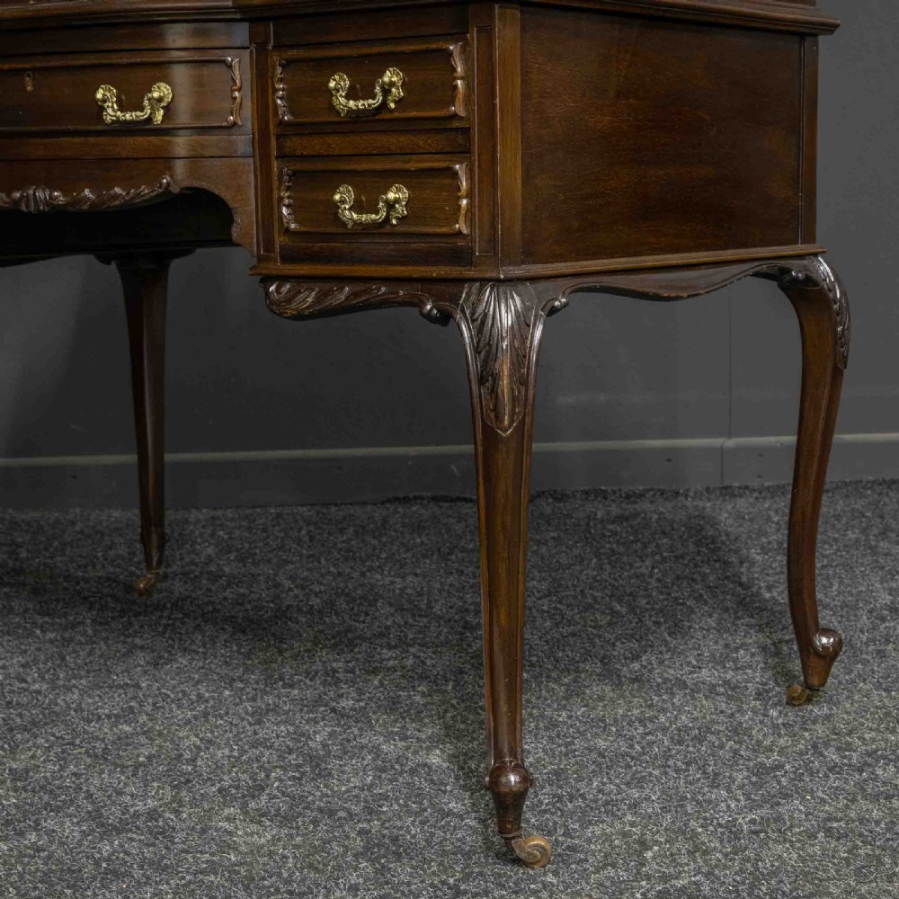 A late Victorian dark mahogany ladies writing desk featuring a green leather inset top, raised mirror superstructure, small side drawers, carved cabriole legs, and brass handles. View XII