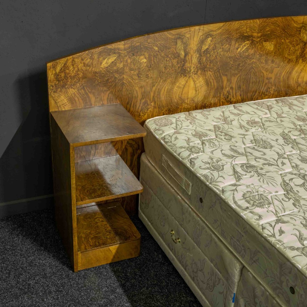 An Art Deco burr walnut headboard featuring a gently arched crest and integrated open bedside shelves on both sides. View III