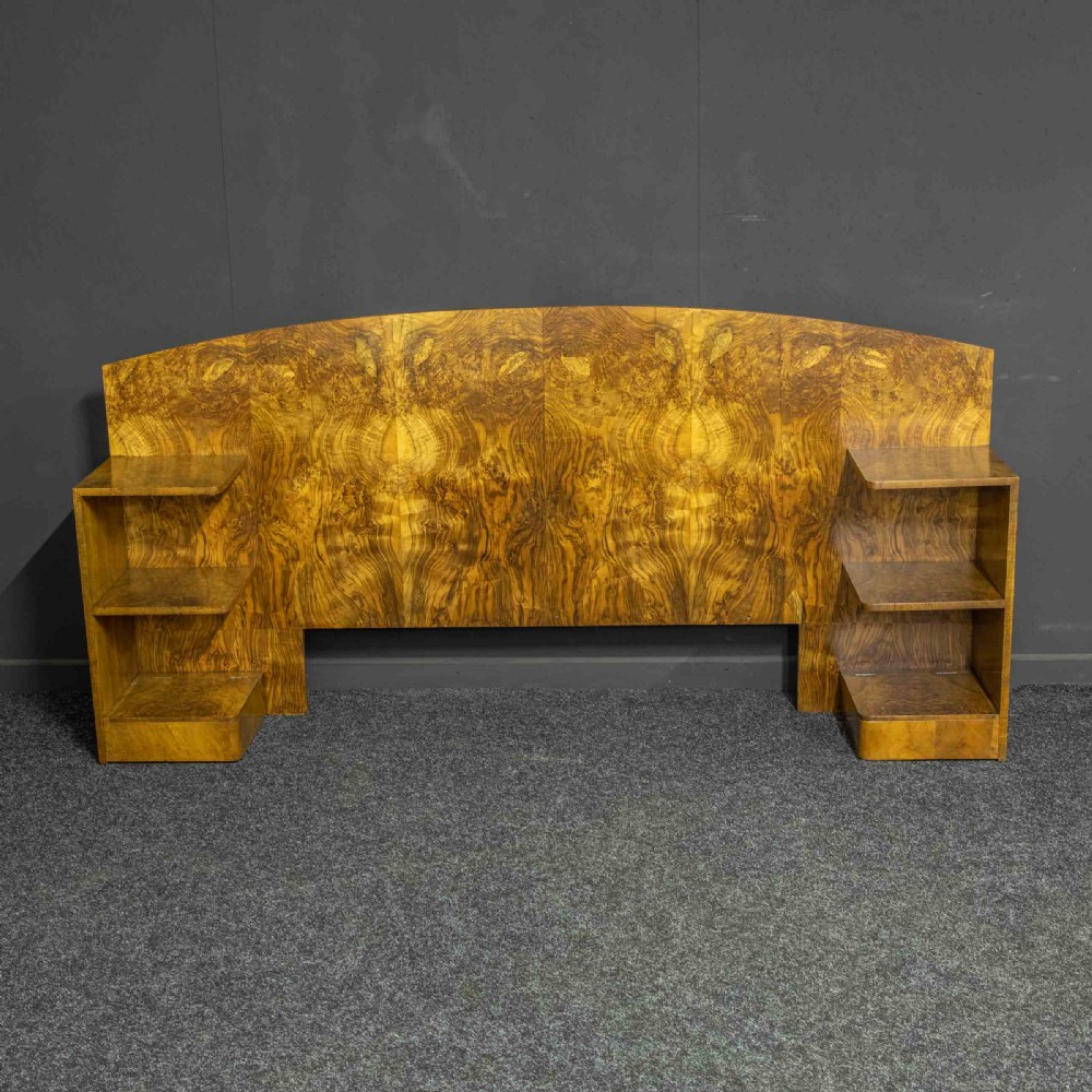 An Art Deco burr walnut headboard featuring a gently arched crest and integrated open bedside shelves on both sides. View IV