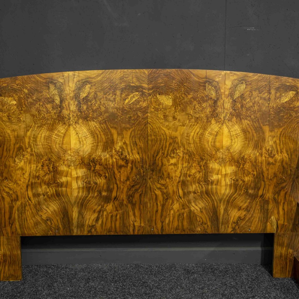 An Art Deco burr walnut headboard featuring a gently arched crest and integrated open bedside shelves on both sides. View VII