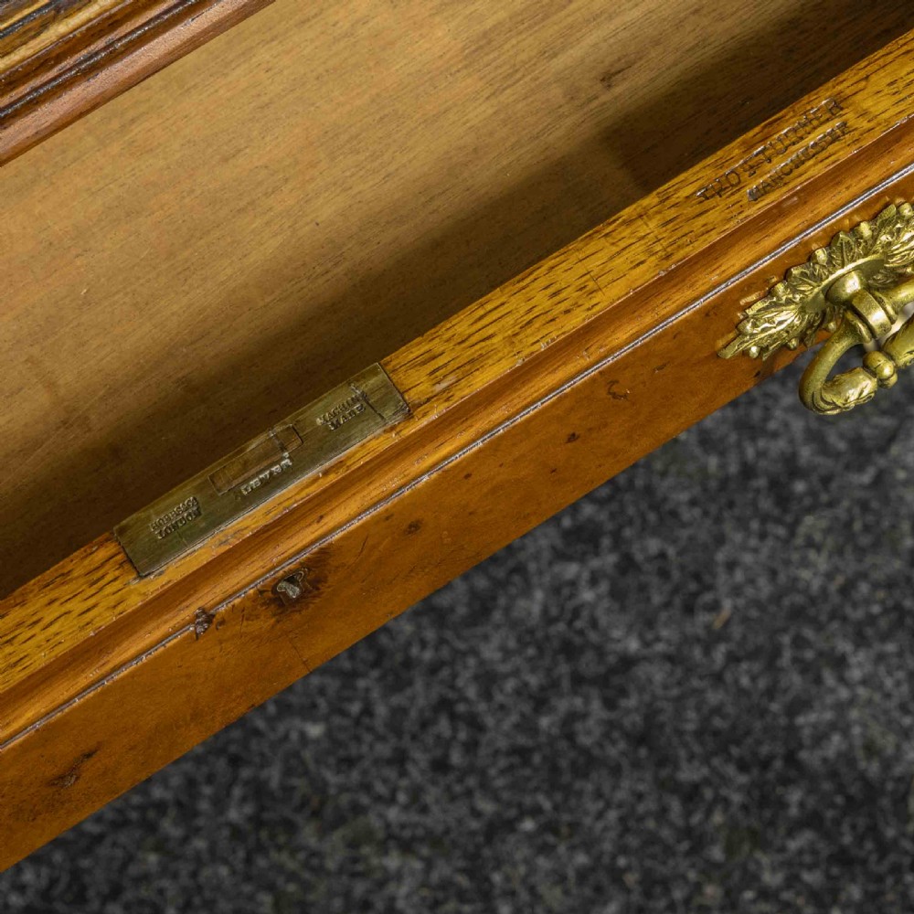 A late Victorian pollard oak desk featuring a central sloped green leather writing surface, carved backboard cresting, tiered shelves with mirrors, and brass-handled drawers. View IX