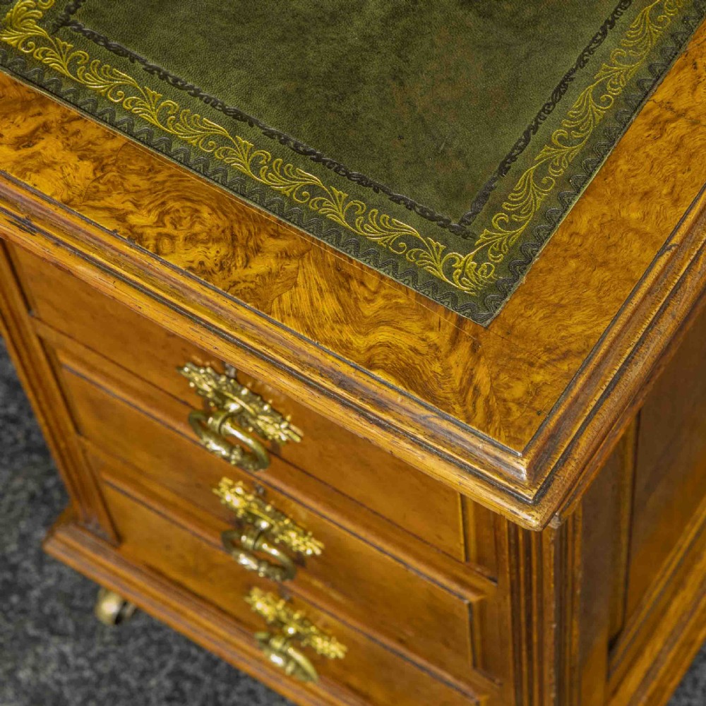 A late Victorian pollard oak desk featuring a central sloped green leather writing surface, carved backboard cresting, tiered shelves with mirrors, and brass-handled drawers. View XII