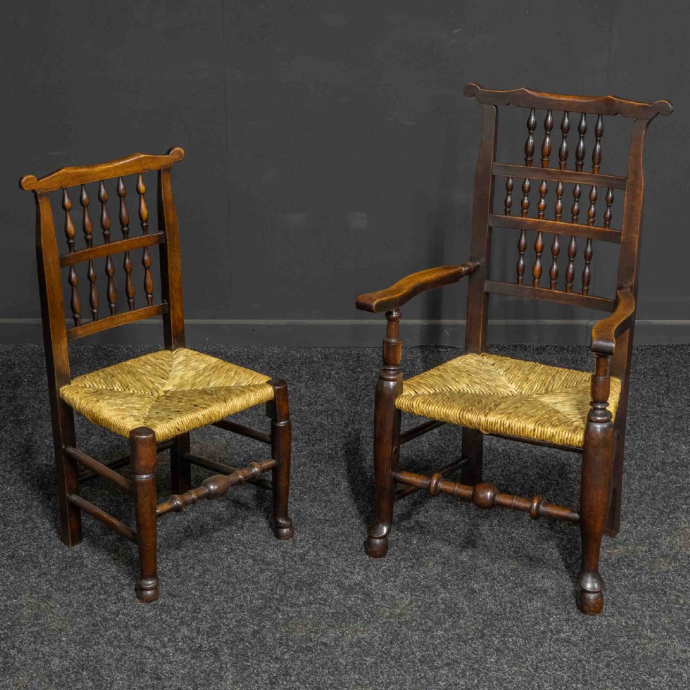 A set of eight Georgian dark oak spindleback dining chairs featuring two carver armchairs and six single side chairs with woven rush seats. View II