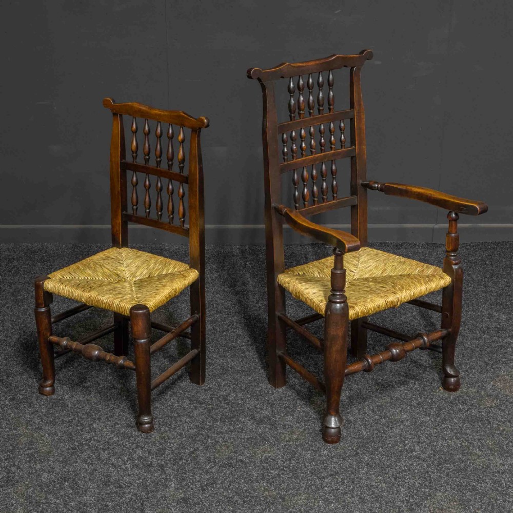 A set of eight Georgian dark oak spindleback dining chairs featuring two carver armchairs and six single side chairs with woven rush seats. View III