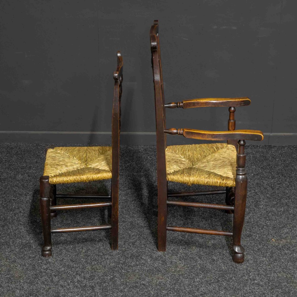 A set of eight Georgian dark oak spindleback dining chairs featuring two carver armchairs and six single side chairs with woven rush seats. View IV