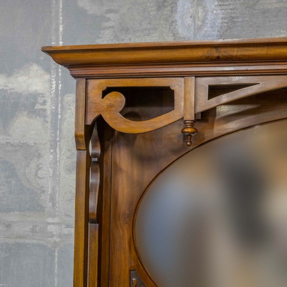 A Victorian walnut sideboard featuring carved panelled cupboard doors, drawers with brass handles, and a mirrored upper shelf structure. View VII