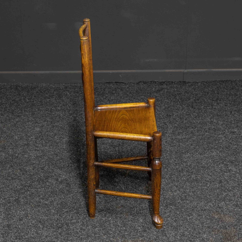 A set of sixteen 18th-century country oak dining chairs featuring spindle backrests, wooden panel seats, turned legs, and stretchers. View VI