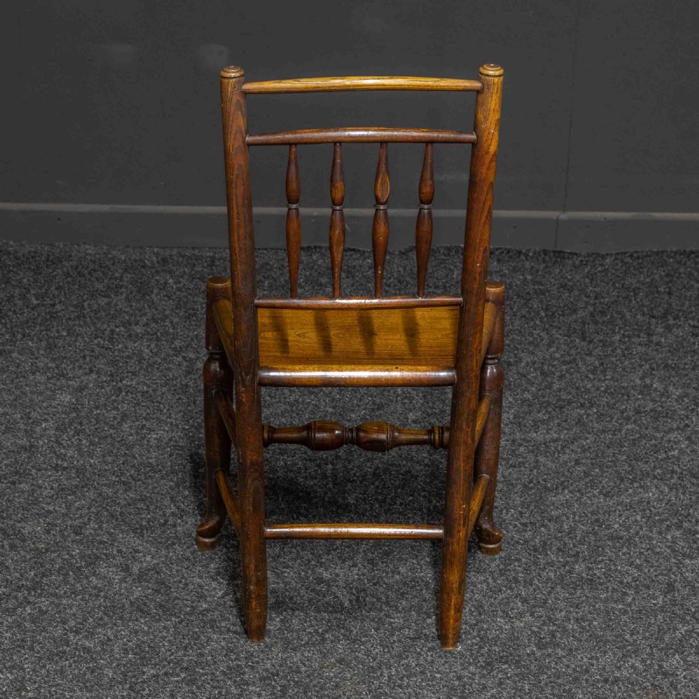A set of sixteen 18th-century country oak dining chairs featuring spindle backrests, wooden panel seats, turned legs, and stretchers. View VII