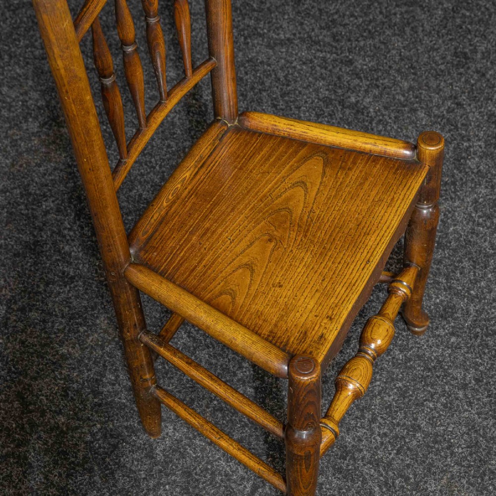 A set of sixteen 18th-century country oak dining chairs featuring spindle backrests, wooden panel seats, turned legs, and stretchers. View VIII