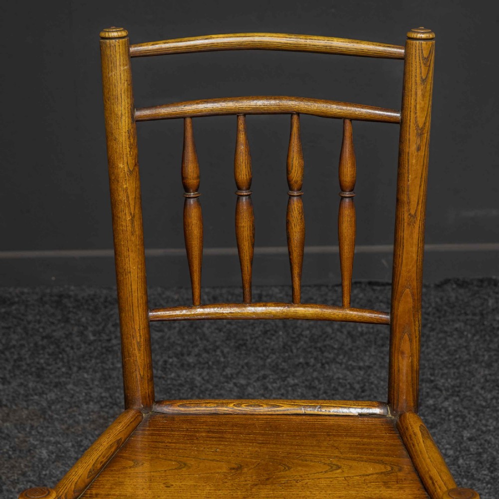 A set of sixteen 18th-century country oak dining chairs featuring spindle backrests, wooden panel seats, turned legs, and stretchers. View IX