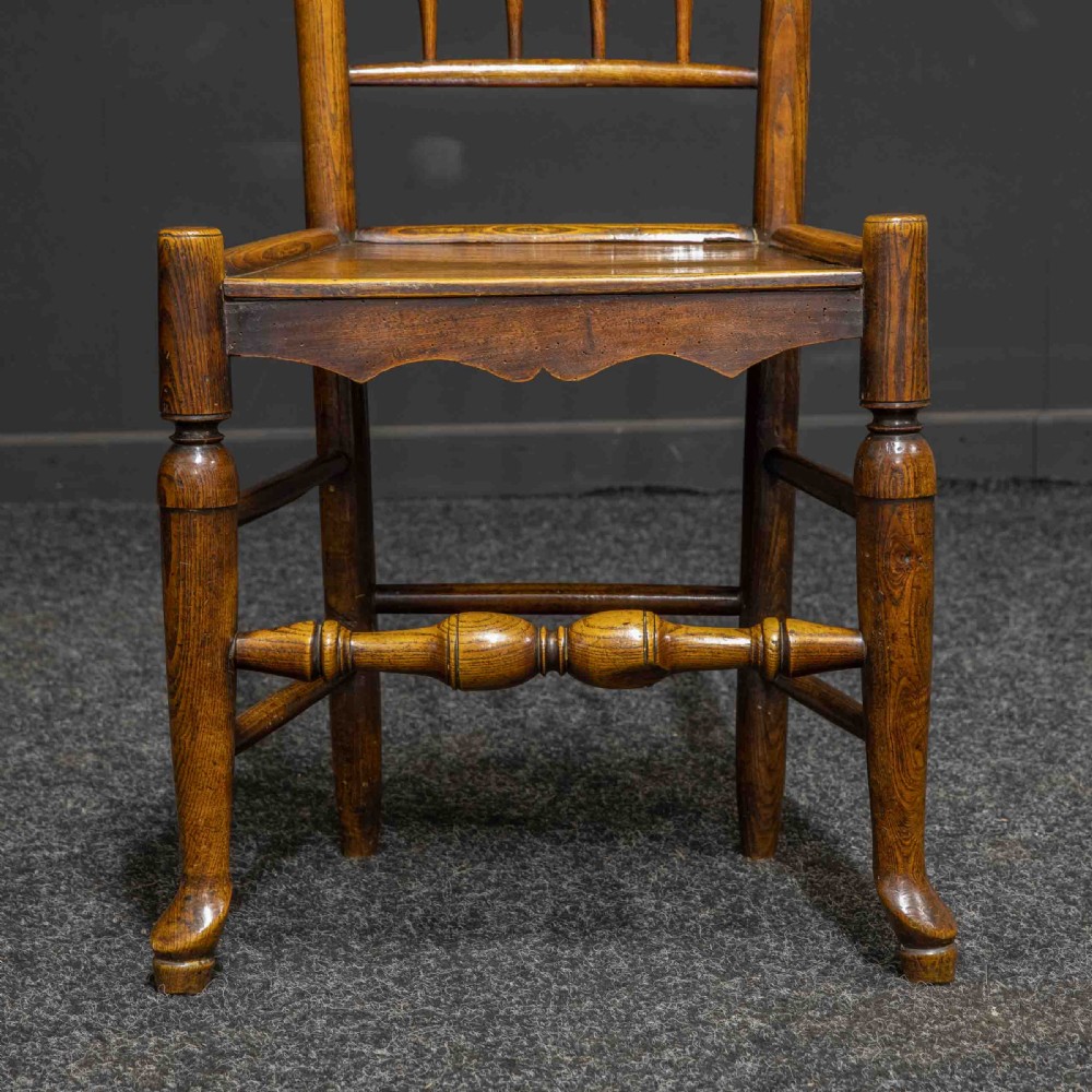 A set of sixteen 18th-century country oak dining chairs featuring spindle backrests, wooden panel seats, turned legs, and stretchers. View XI