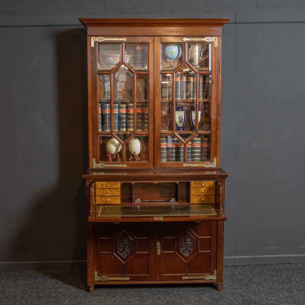 A tall Victorian walnut secretaire bookcase featuring a glazed upper display section, a drop-down desk compartment, and carved double doors at the base with decorative brass mounts. View II