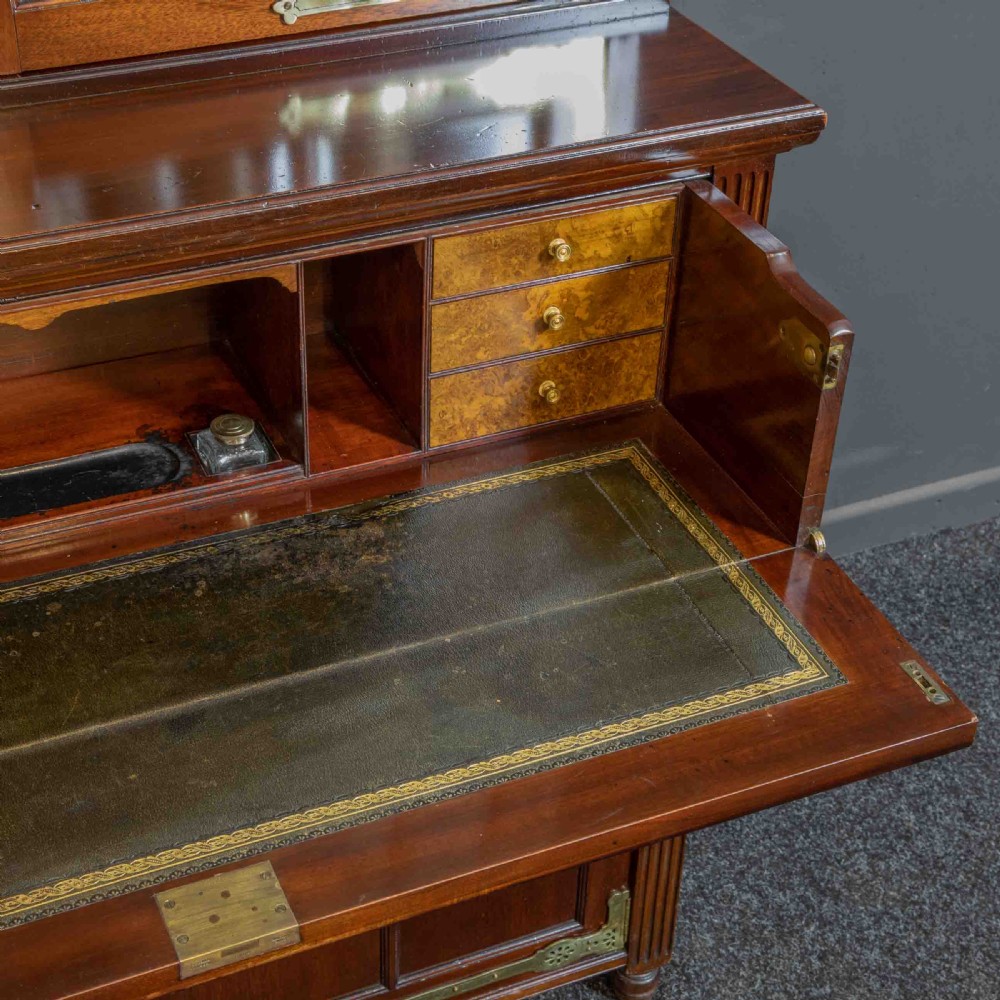 A tall Victorian walnut secretaire bookcase featuring a glazed upper display section, a drop-down desk compartment, and carved double doors at the base with decorative brass mounts. View IV