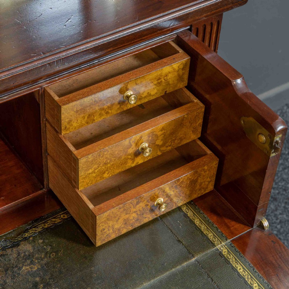 A tall Victorian walnut secretaire bookcase featuring a glazed upper display section, a drop-down desk compartment, and carved double doors at the base with decorative brass mounts. View V