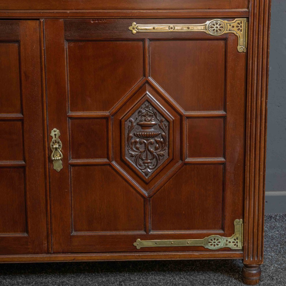 A tall Victorian walnut secretaire bookcase featuring a glazed upper display section, a drop-down desk compartment, and carved double doors at the base with decorative brass mounts. View XII