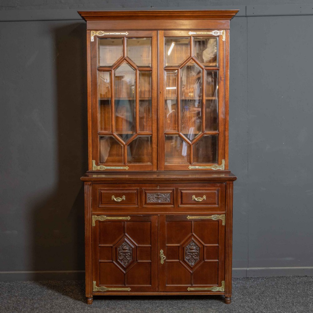 A tall Victorian walnut secretaire bookcase featuring a glazed upper display section, a drop-down desk compartment, and carved double doors at the base with decorative brass mounts. View XVI