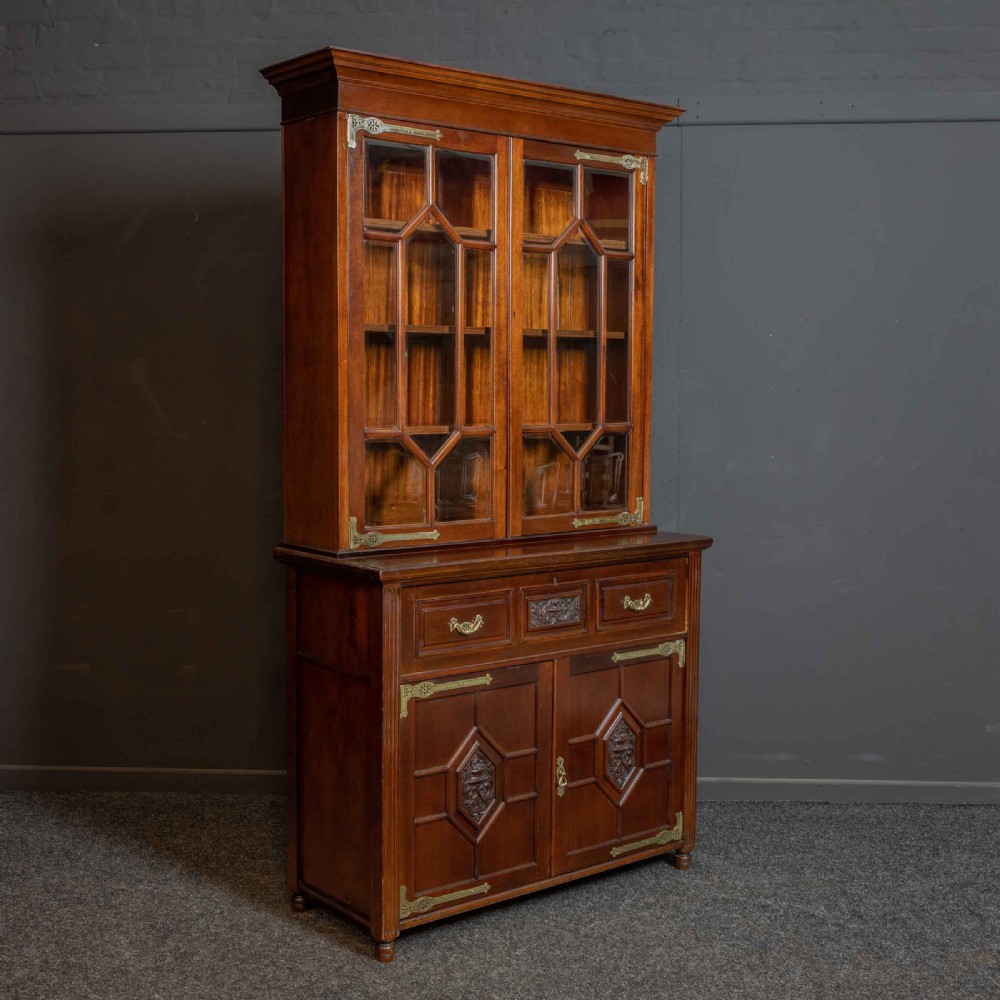 A tall Victorian walnut secretaire bookcase featuring a glazed upper display section, a drop-down desk compartment, and carved double doors at the base with decorative brass mounts. View XVII