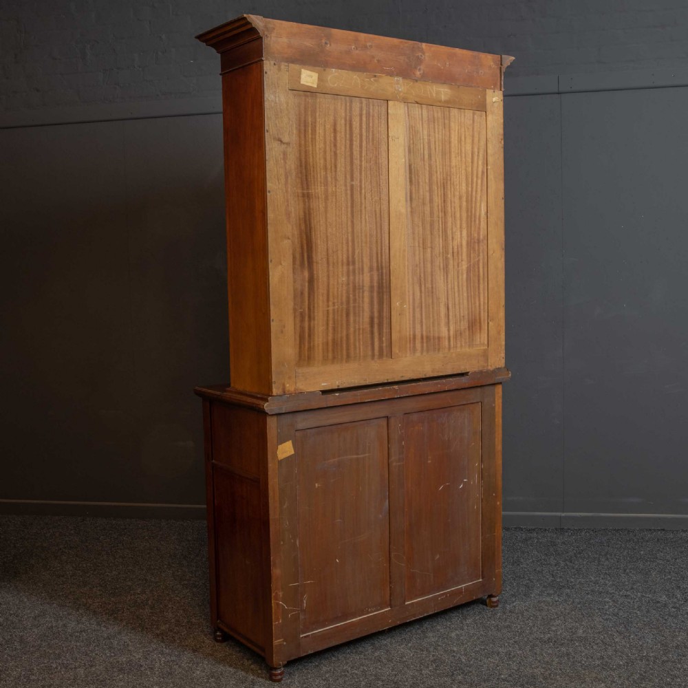 A tall Victorian walnut secretaire bookcase featuring a glazed upper display section, a drop-down desk compartment, and carved double doors at the base with decorative brass mounts. View XIX