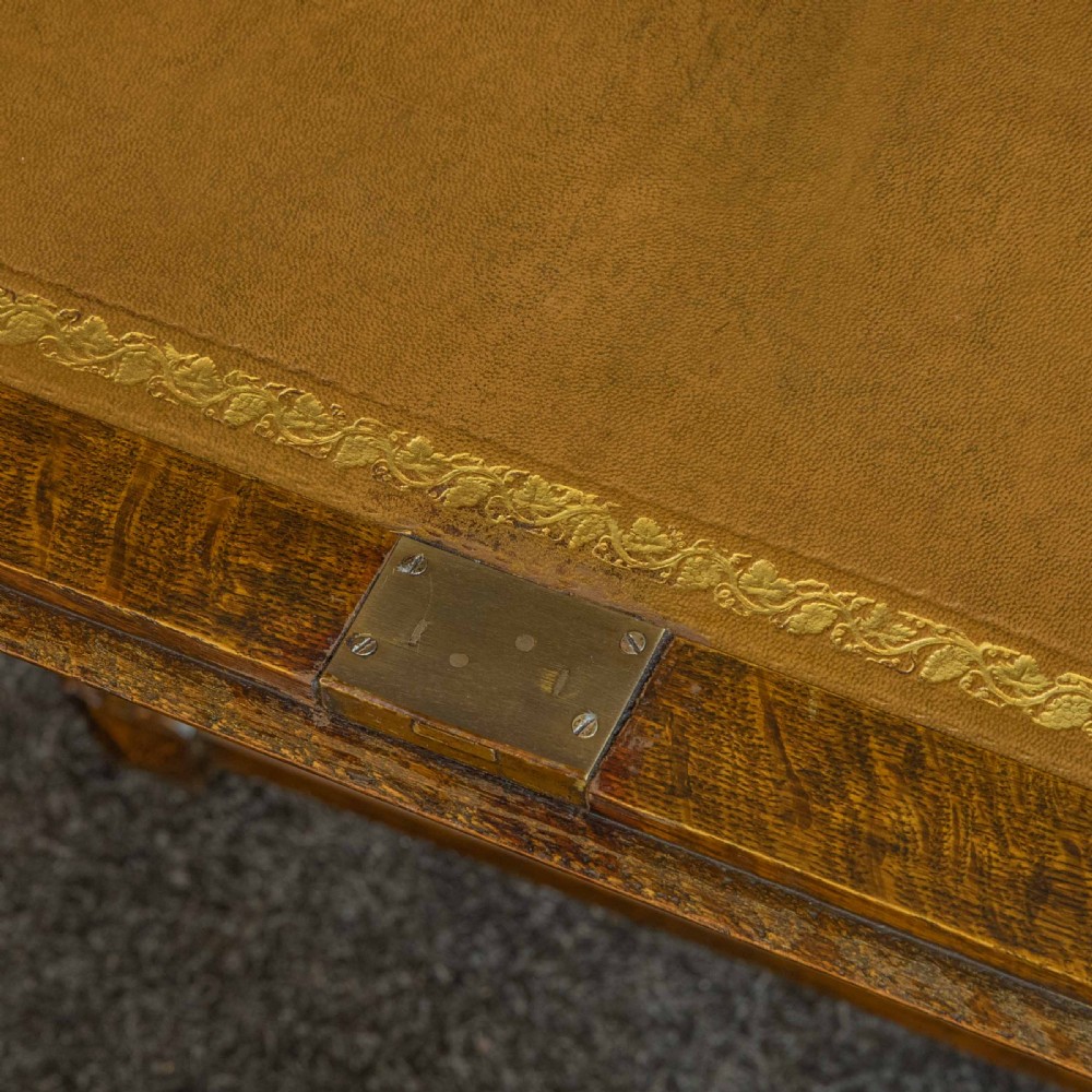 A medium brown carved oak writing bureau with a slant front lid above a double door cupboard, detailed with carved oval foliate panels and turned feet. View X