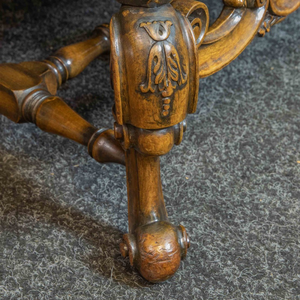 A William and Mary style walnut sofa featuring a high curved woven cane backrest, gold velvet cushion seat, and intricately carved scrollwork base. View XII