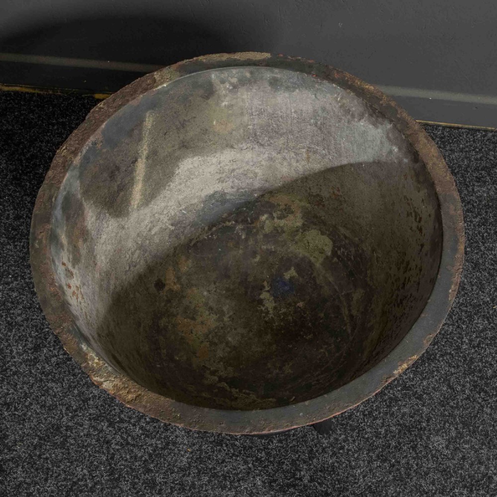 A deep circular copper tub painted orange on the outer side, resting in a black circular stand. View IV