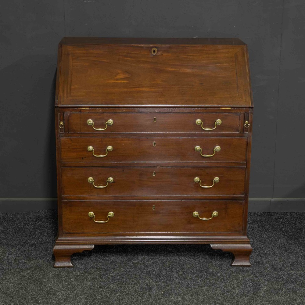 A Georgian mahogany writing bureau featuring a sloped fall-front lid above four graduated drawers with brass swan-neck handles, supported on bracket feet. View II