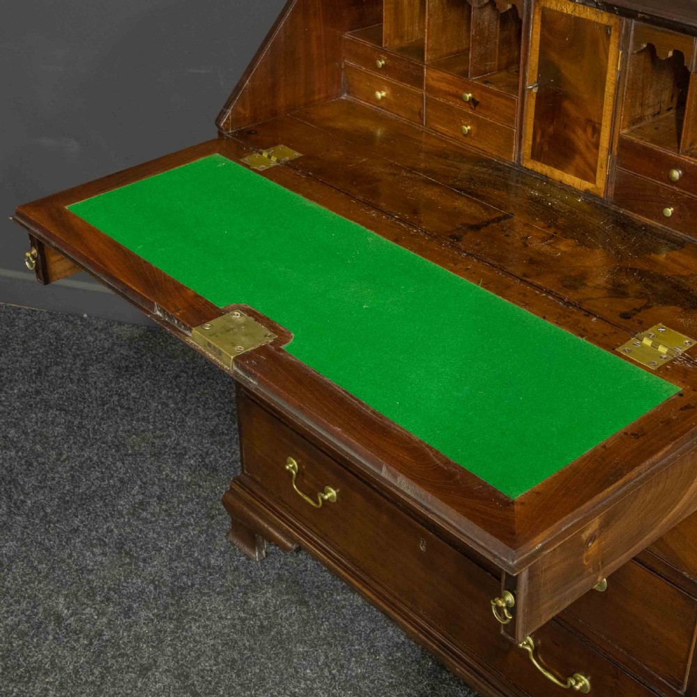 A Georgian mahogany writing bureau featuring a sloped fall-front lid above four graduated drawers with brass swan-neck handles, supported on bracket feet. View VI