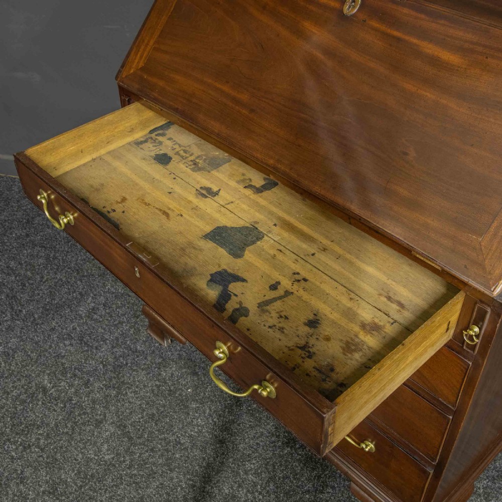 A Georgian mahogany writing bureau featuring a sloped fall-front lid above four graduated drawers with brass swan-neck handles, supported on bracket feet. View IX