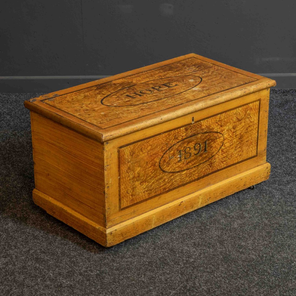 A Victorian pine storage box with a yellow-brown scrumbled painted finish, featuring the word HOPE on the lid and the year 1891 within an oval frame on the front.