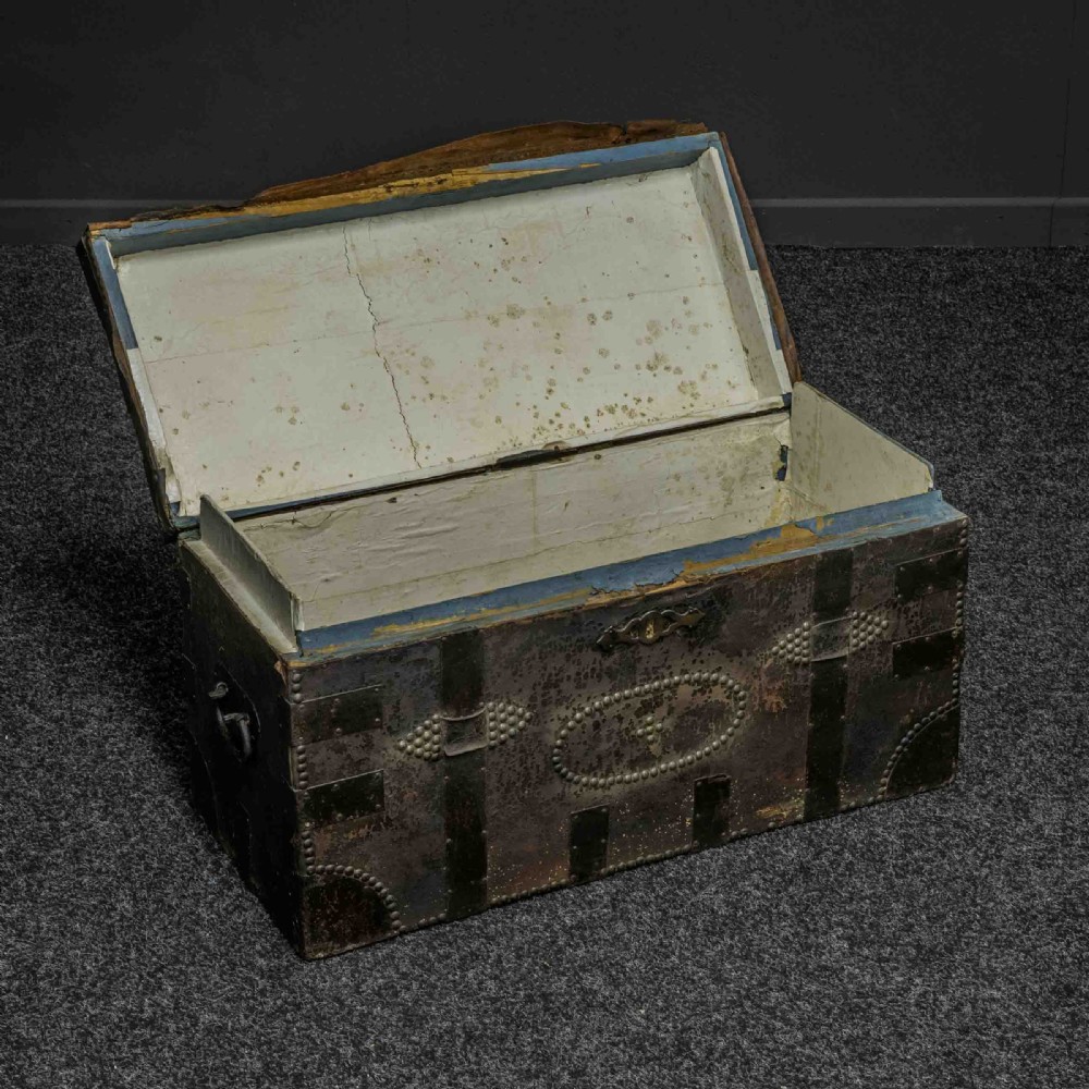 A rectangular Victorian trunk wrapped in dark brown leather with decorative brass studding, metal banding, and iron side handles. View VI