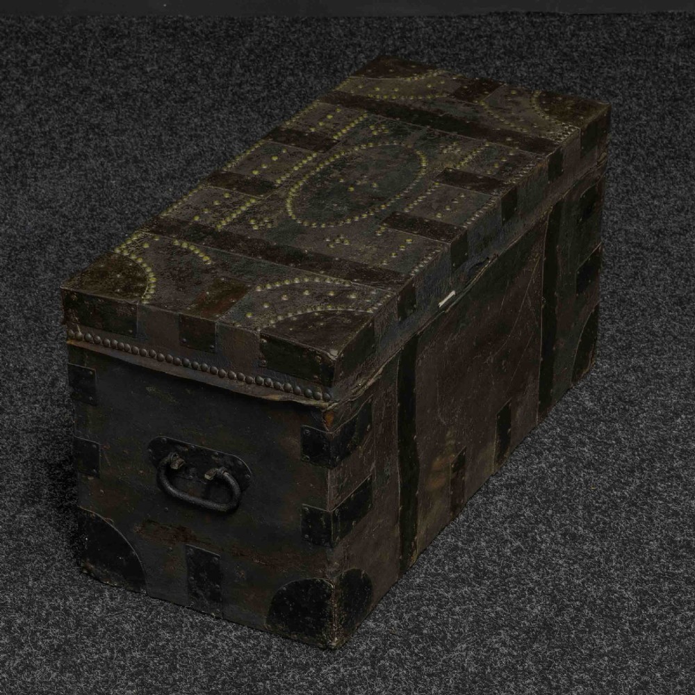 A rectangular Victorian trunk wrapped in dark brown leather with decorative brass studding, metal banding, and iron side handles. View VIII