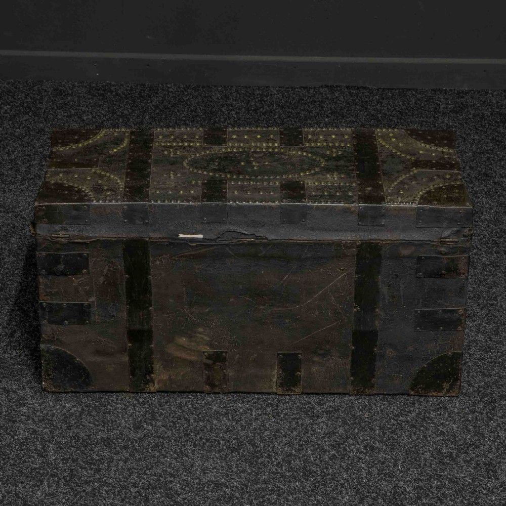 A rectangular Victorian trunk wrapped in dark brown leather with decorative brass studding, metal banding, and iron side handles. View IX