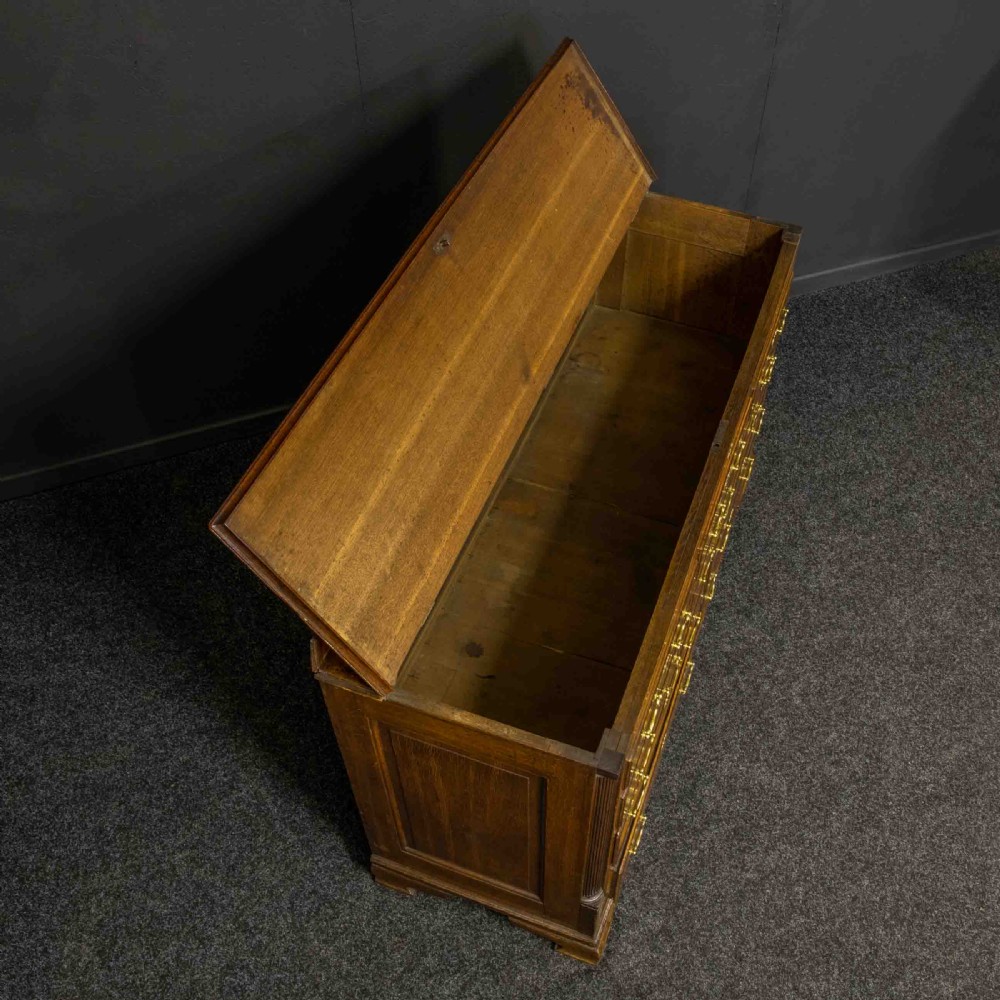 An 18th-century Georgian oak Lancashire mule chest with crossbanded drawer fronts, brass swan-neck handles, and bracket feet. View V