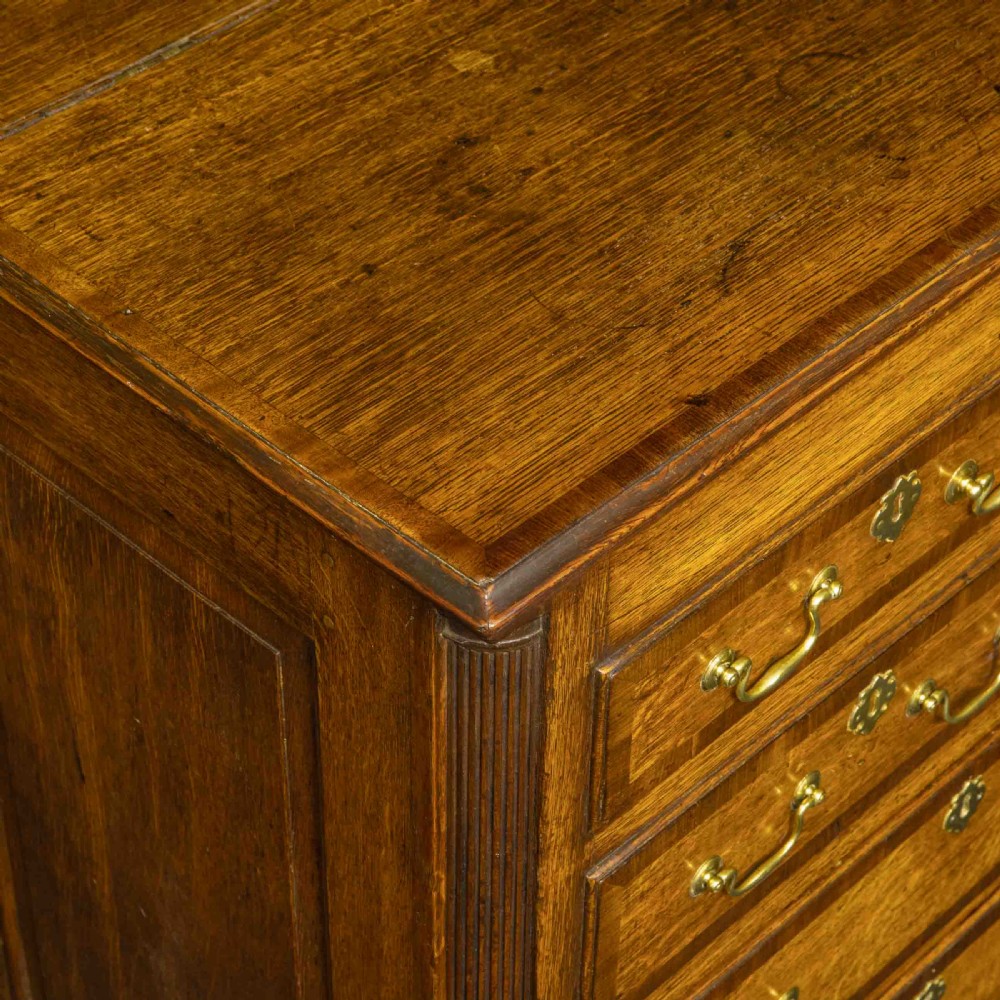 An 18th-century Georgian oak Lancashire mule chest with crossbanded drawer fronts, brass swan-neck handles, and bracket feet. View IX