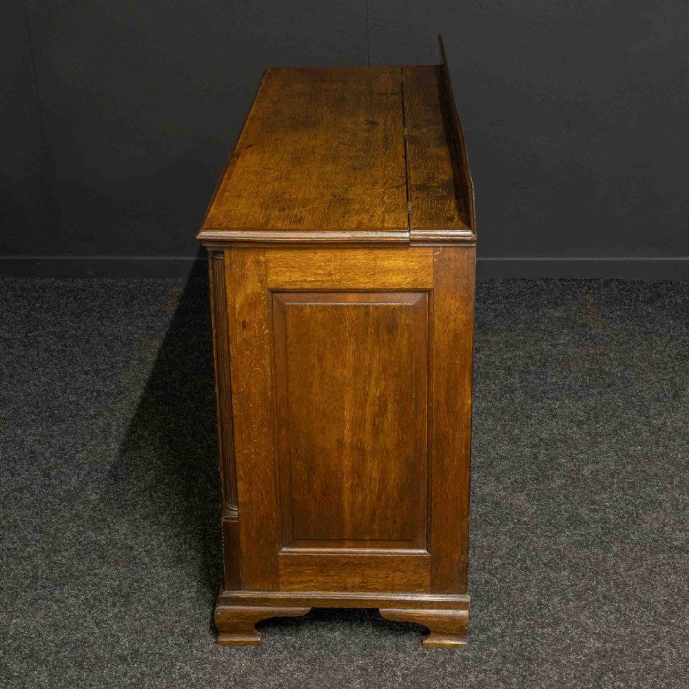 An 18th-century Georgian oak Lancashire mule chest with crossbanded drawer fronts, brass swan-neck handles, and bracket feet. View XII