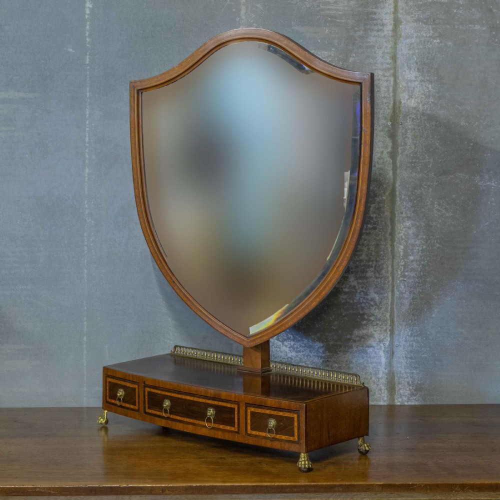 An Edwardian mahogany shield-shaped swing toilet mirror resting on a boxwood inlaid base with drawers and brass feet. View III