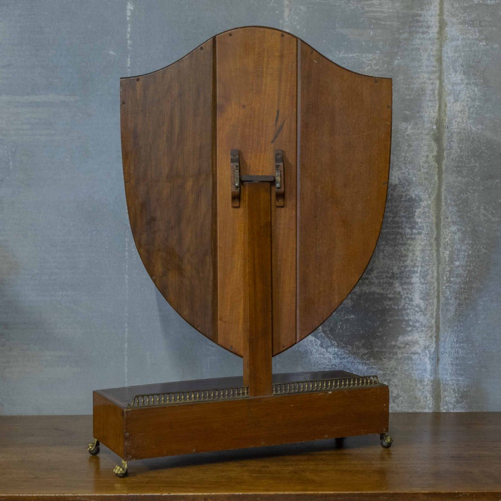 An Edwardian mahogany shield-shaped swing toilet mirror resting on a boxwood inlaid base with drawers and brass feet. View VIII