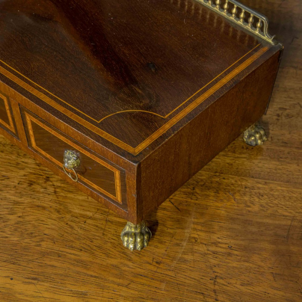 An Edwardian mahogany shield-shaped swing toilet mirror resting on a boxwood inlaid base with drawers and brass feet. View X