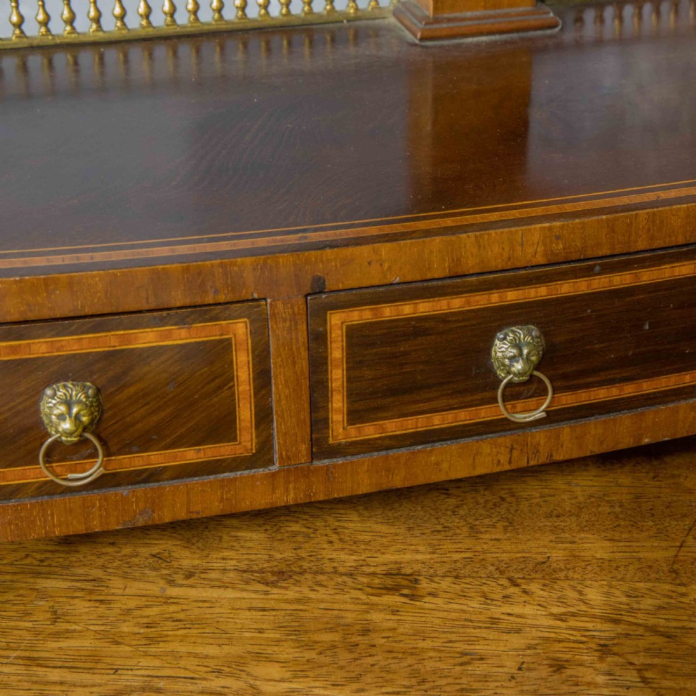 An Edwardian mahogany shield-shaped swing toilet mirror resting on a boxwood inlaid base with drawers and brass feet. View XIV