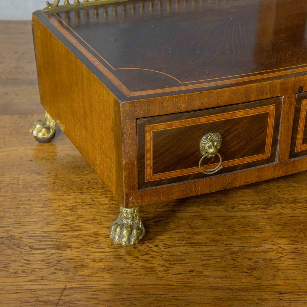 An Edwardian mahogany shield-shaped swing toilet mirror resting on a boxwood inlaid base with drawers and brass feet. View XV