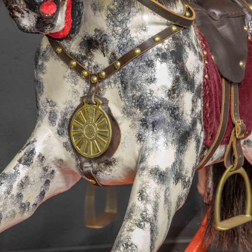 An antique Victorian hand-painted dappled grey wooden rocking horse with a leather saddle and horsehair mane mounted on an orange bow rocker. View V