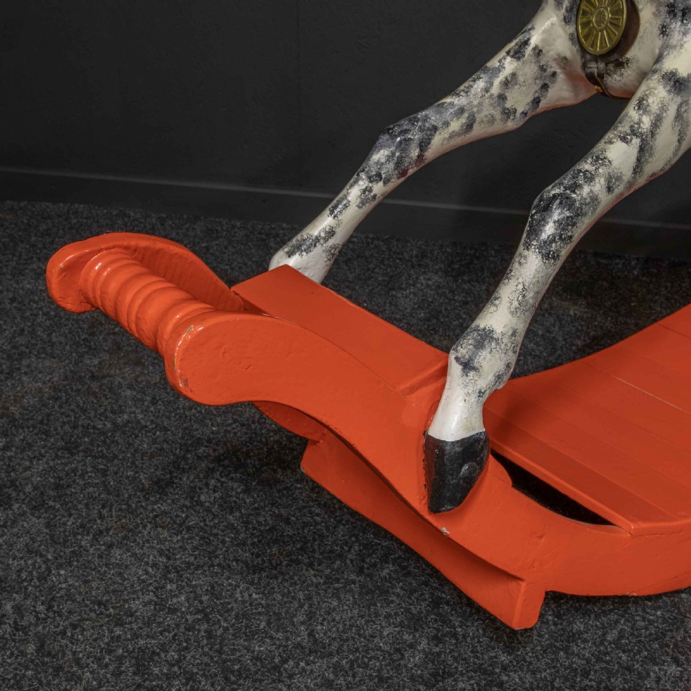 An antique Victorian hand-painted dappled grey wooden rocking horse with a leather saddle and horsehair mane mounted on an orange bow rocker. View VI