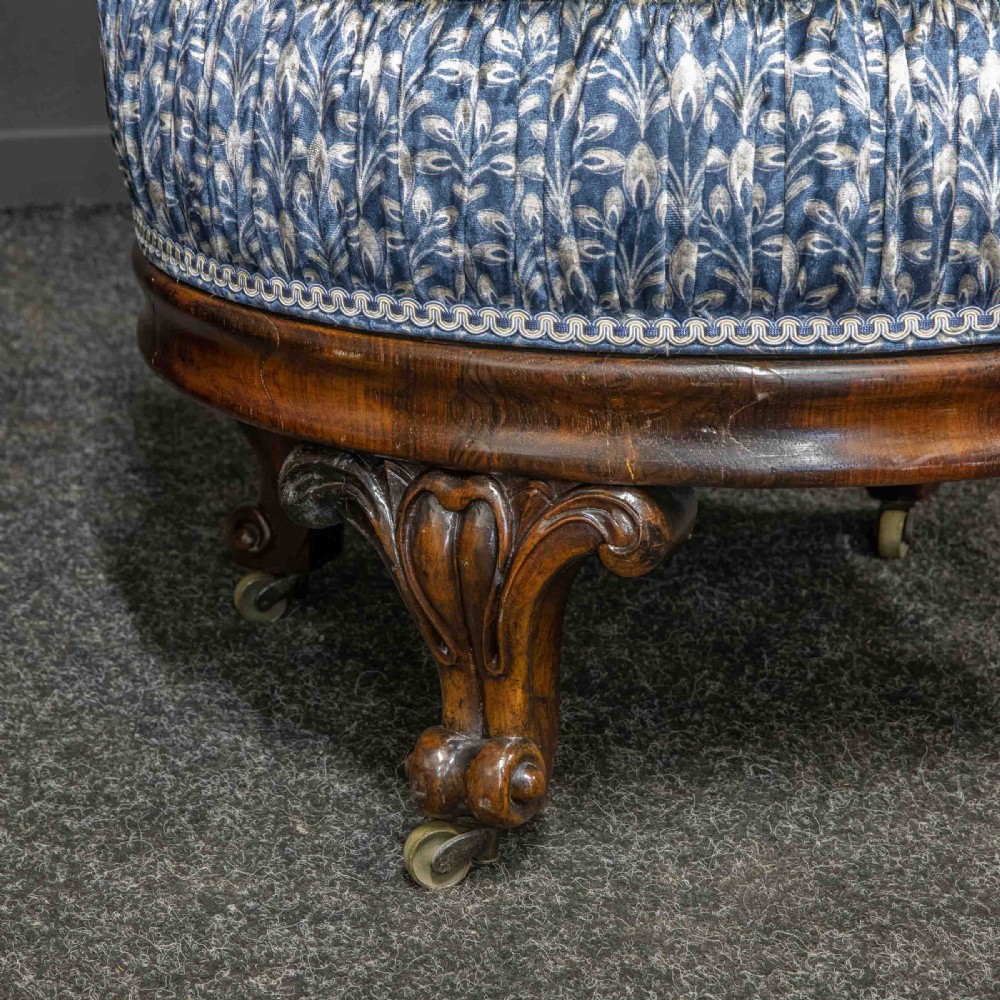 A pair of Victorian armchairs with carved timber frames, blue patterned button-back fabric upholstery, and rounded seat cushions on brass castors. View IV