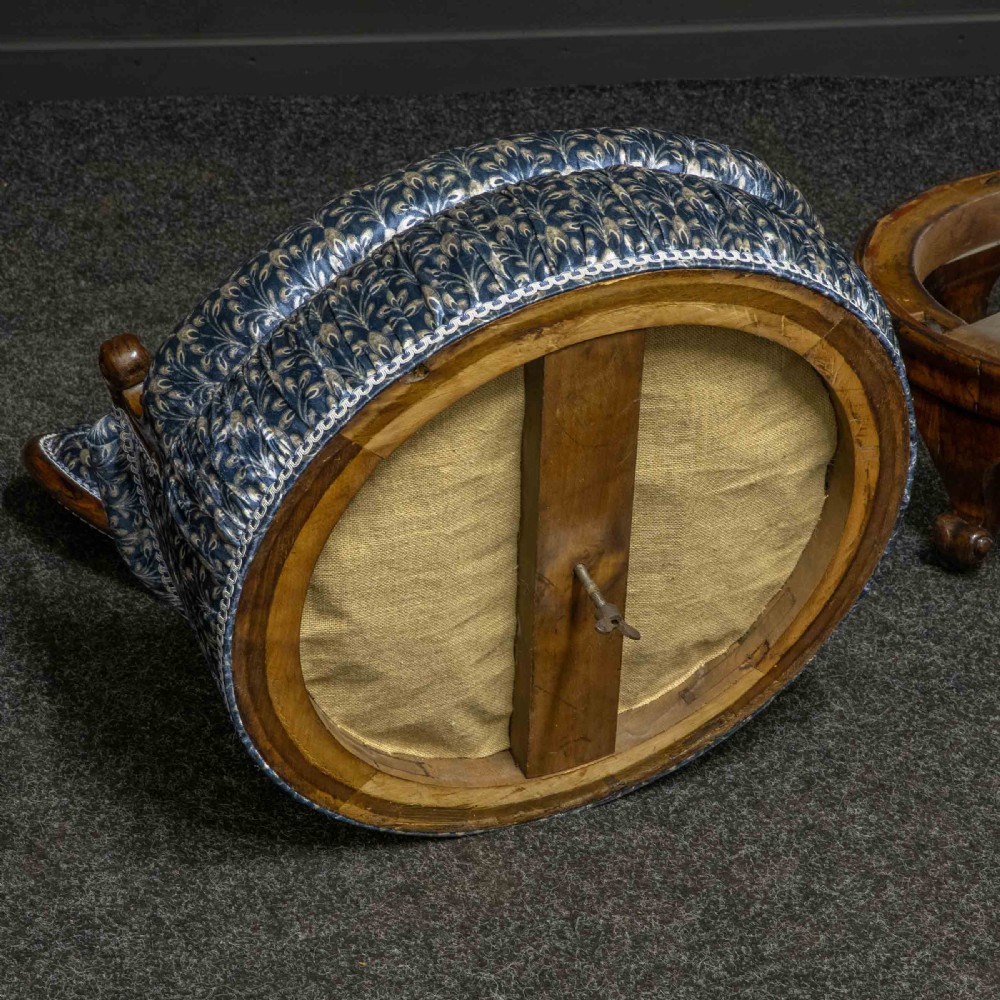 A pair of Victorian armchairs with carved timber frames, blue patterned button-back fabric upholstery, and rounded seat cushions on brass castors. View XV